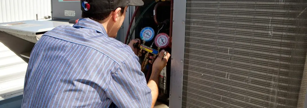 HVAC technician servicing a condenser unit in Mount Morris